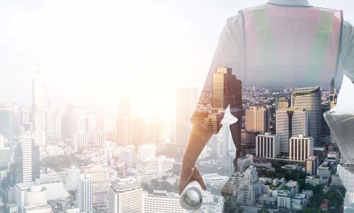A project manager overlooking a modern city skyline, symbolizing coordination of construction, architectural planning, and project management services.
